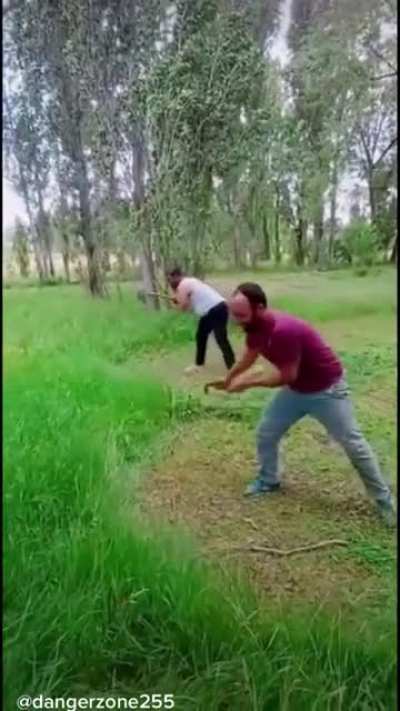 2 people cutting long grass
