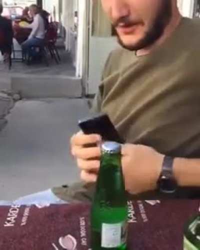 Trying to open a glass bottle with a phone.