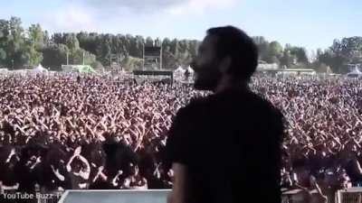 A band’s lighting technician signals to his colleague as he tests the stage set-up - and the crowd copies him.