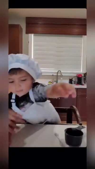 A kid trying to back a cake for the first time
