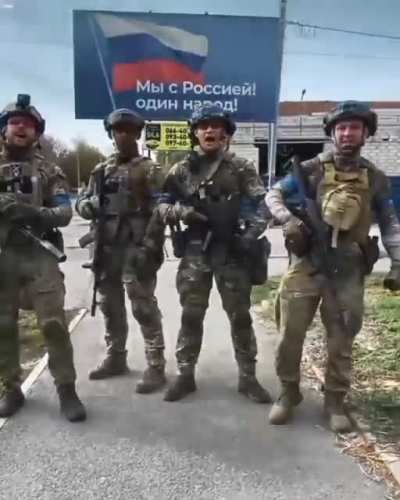Ukrainian soldiers reply to Russia in front of billboard 