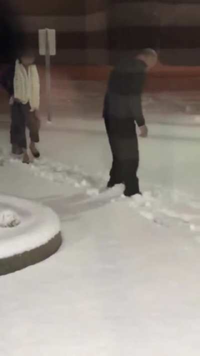 Husband clearing the snow path for his wife