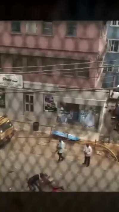 Nigerian policemen shooting at a downed protester