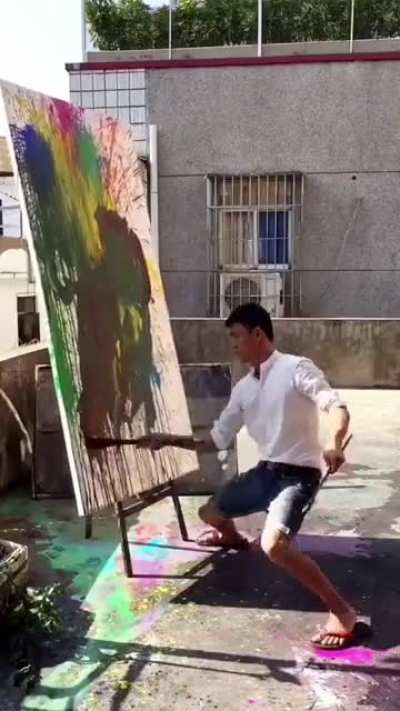 This man splashes paint onto a canvas.