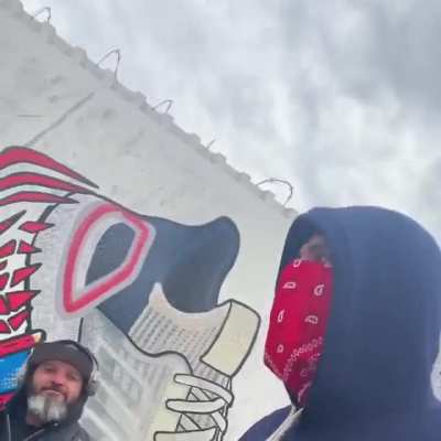 Graffiti artist goes over street art in Brooklyn while it's being patient.