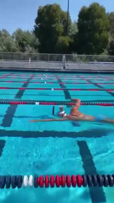 Olympic swimmer keeps head so steady while swimming a glass of chocolate milk placed on the back of her head doesn't spill a drop