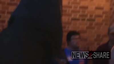 A masked Proud Boy attacks a young woman outside of Penn State University. This was shortly after a speech by Gavin McInnes was cancelled because other Proud Boys maced students and press at the campus.