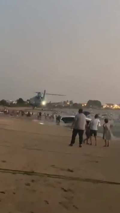 Spanish Police Helicopter Flying Low To Try To Avoid People On The Beach To Steal Drugs From A Chased 'Narco-Boat'. Cadiz, Spain