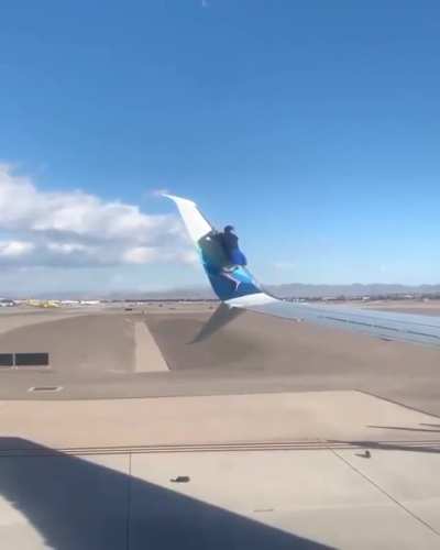 Man climbs onto the wing of a plane waiting for take-off after breaking into a Las Vegas airport runway area