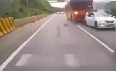 A chartered tourist bus plows through a slowdown in traffic.