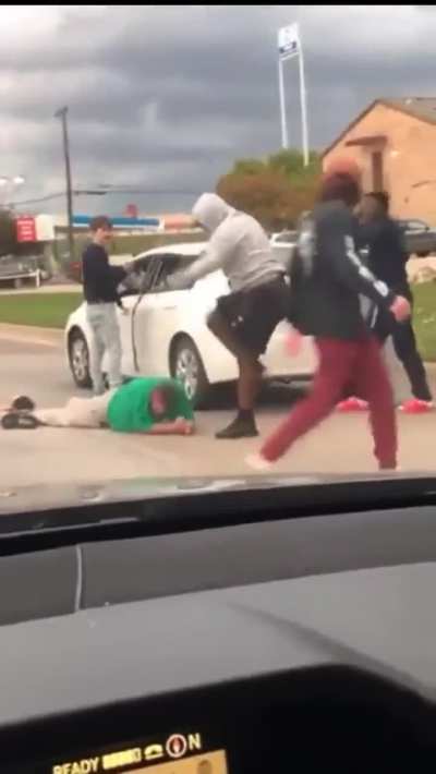 Someone gets beaten in the middle of the road
