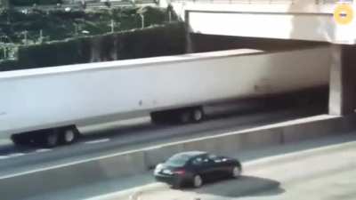 Truck passing under bridge.