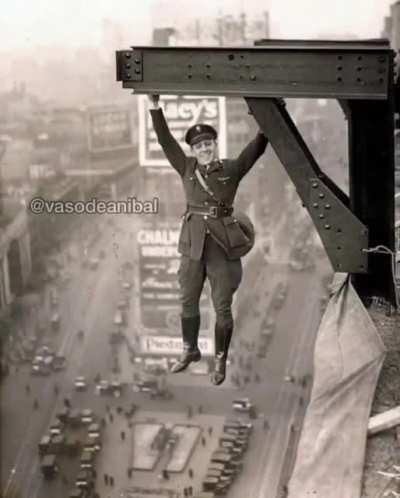 A New York City Police Officer poses hanging over Times Square , 1920.