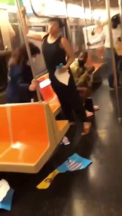 Lady is incensed with ads on the subway. She destroys them while also ranting about topical issues.