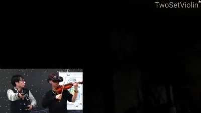 Musician plays violin while playing a VR horror game.