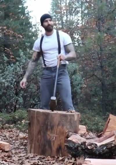 Man splitting wood with a splitting maul