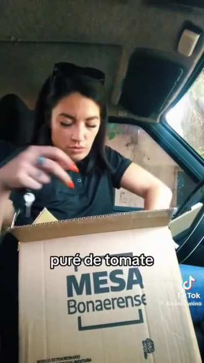 Esta mujer muestra lo que contiene la caja de la Mesa Bonaerense que reparte el gobierno de Kicillof, aunque no parece necesitarla.