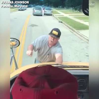 Guy jumps on hood of a school bus after a student threw a water bottle that hit his car