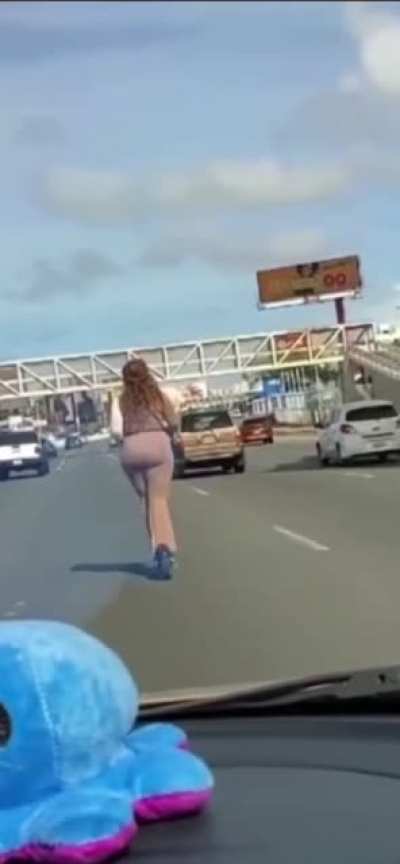 Tourist rides an electric scooter in the middle of a busy highway
