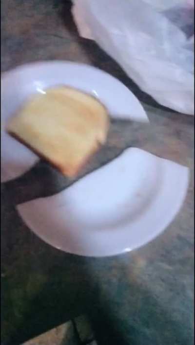 Putting a piece of toast on a plate
