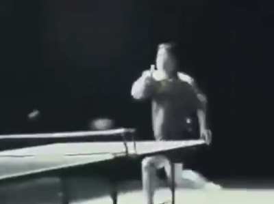 Bruce Lee playing ping-pong with nunchucks.