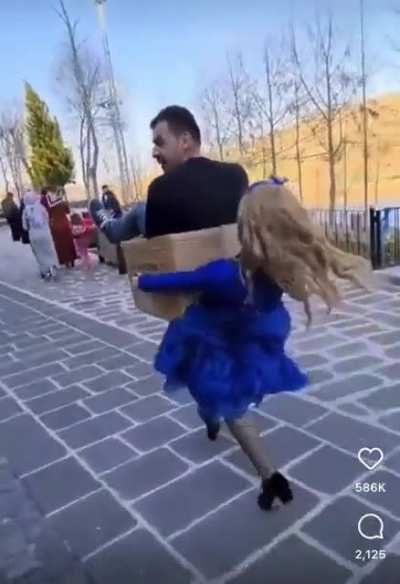Woman carrying man in a box
