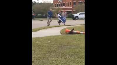 Man attempts to use political flag as a sword in the middle of an intersection