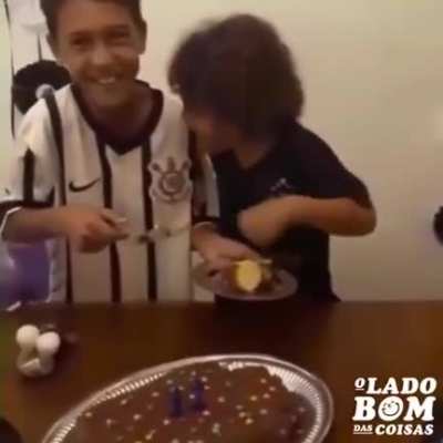 Little brother's reaction upon receiving the first piece of his brother's birthday cake.