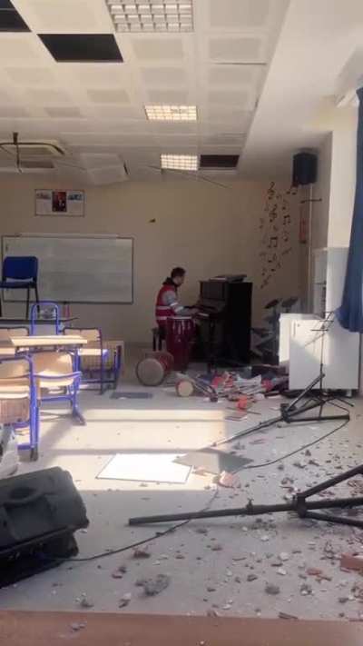 A guy playing the piano amidst the ruins of a school in Antakya, Türkiye.