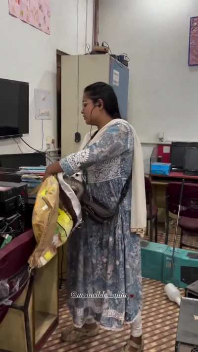 Lady is called to check the cables at a computer cafe in India