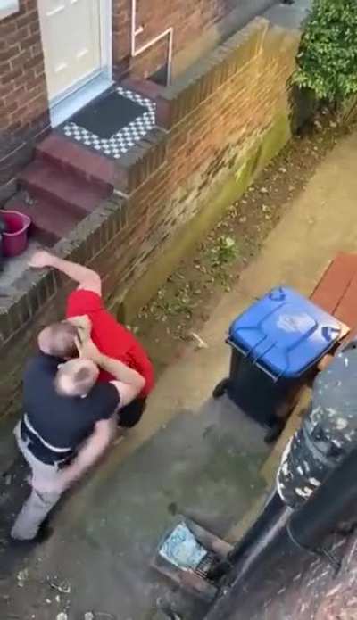 'Gentlemen' in the UK having a punch-up over one of them fixing a large wooden cross to a shared back door.