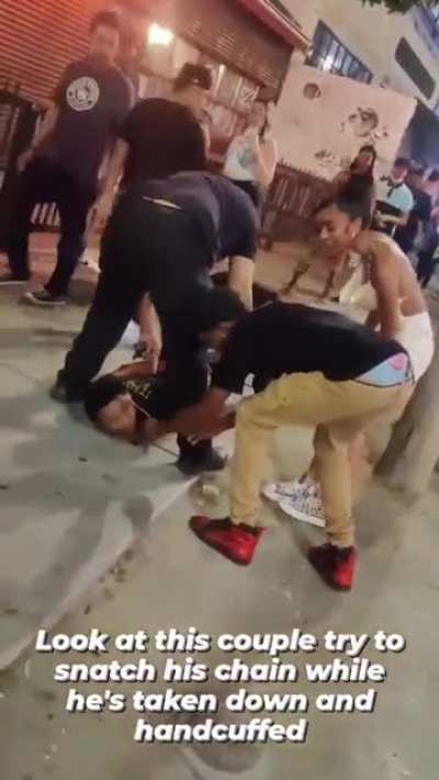 Look at this Jabroni couple try and steal this dudes chain while he's being handcuffed
