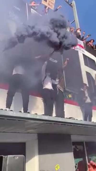 Football fan trying to get down from a ledge after celebrating