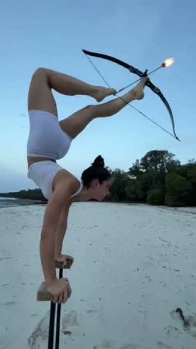 Woman shooting arrows with her feet