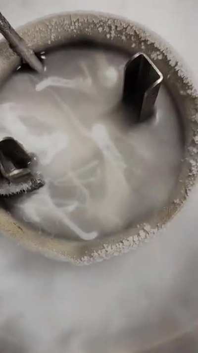 Liquid nitrogen poured over another liquid