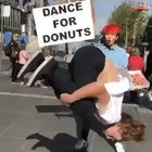 Guy offering donuts to people showcasing their dancing skills