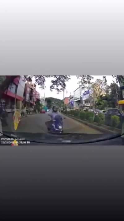 Reckless biker rides wrong lane, nearly collides head-on with a car