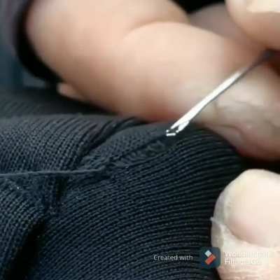 Small bodkin being used to repair run in knit material.