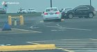 Lady tries to drive off with a curb stuck under her car