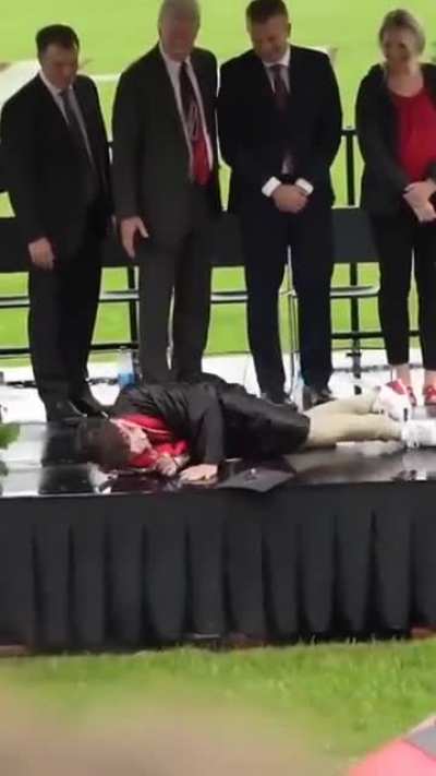 Kid tries to perform a cartwheel at graduation.