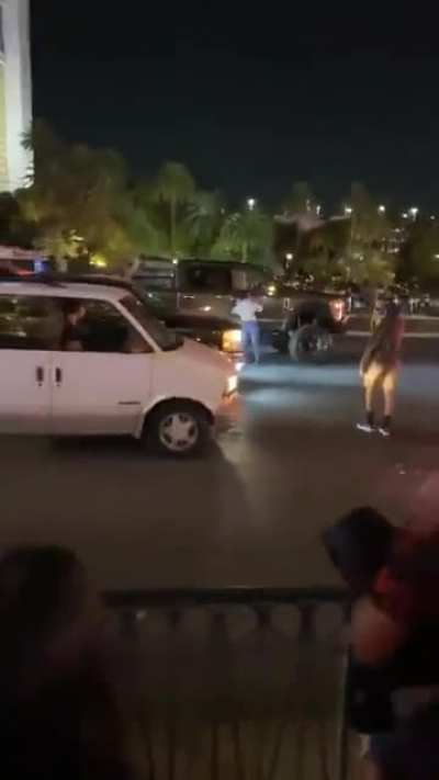 Anti-Trump protestor bangs on windows, doors of a pickup with Trump flag flying. Truck's driver runs out and shoves protestor