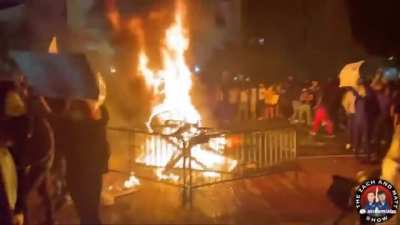 Rioters making a fire with random objects and trees outside the White House