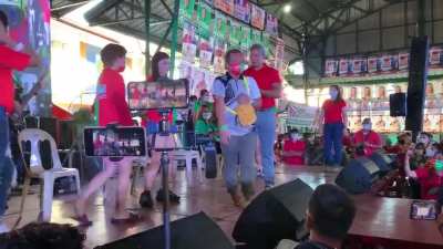 Cavite governor Jonvic Remulla giving away money at a Marcos-Duterte rally