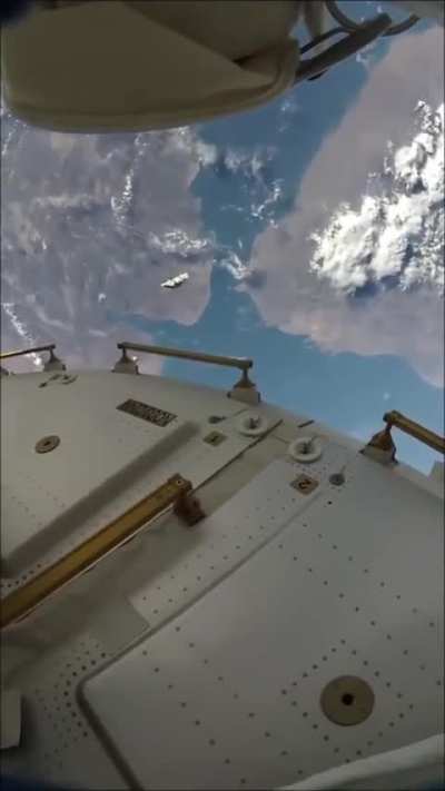 Astronauts on a spacewalk with visible space junk orbiting nearby.