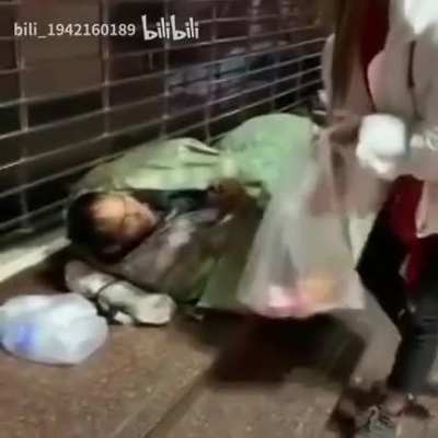 Kind girl tries to give a homeless man some food