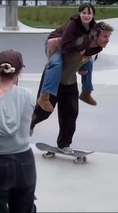 Giving someone a piggy back while on a skateboard