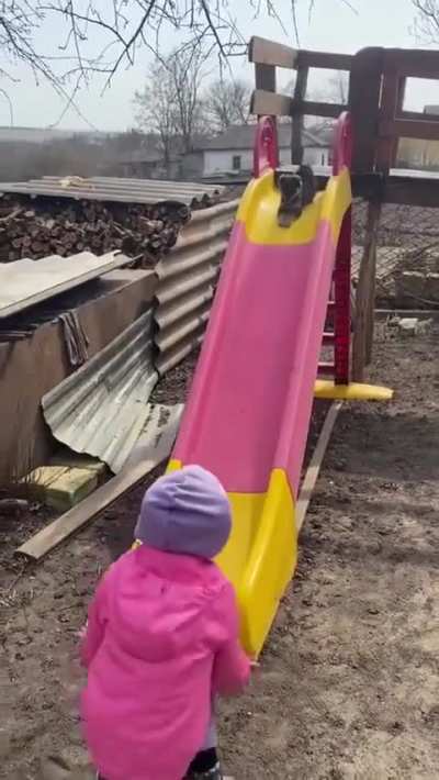 A little girl teaches her puppy how slide (and he loves it)