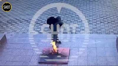 Russian youth uses a fire extinguisher on an eternal flame monument