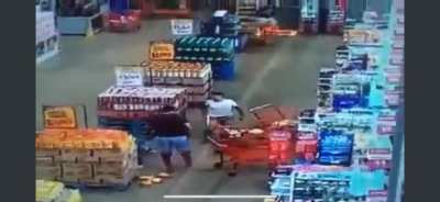 Guy gets mad at person behind him in line so he throws a shopping cart at them.