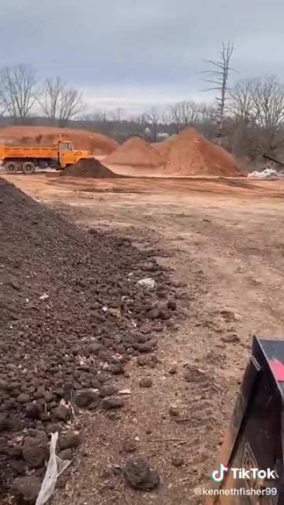 Brick thrown into a dirt pile